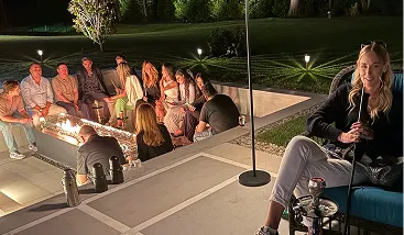 Friends relaxing around a fire pit at a backyard event with hookah service in NYC